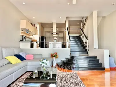 Spacious modern living room with stylish staircase and open layout kitchen