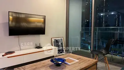 Modern living room with sleek TV setup and city view balcony at night.