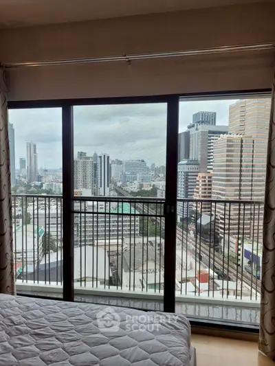 Stunning city view from modern bedroom with large windows and balcony access.