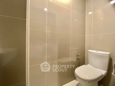 Modern bathroom with sleek tiles and contemporary toilet design.