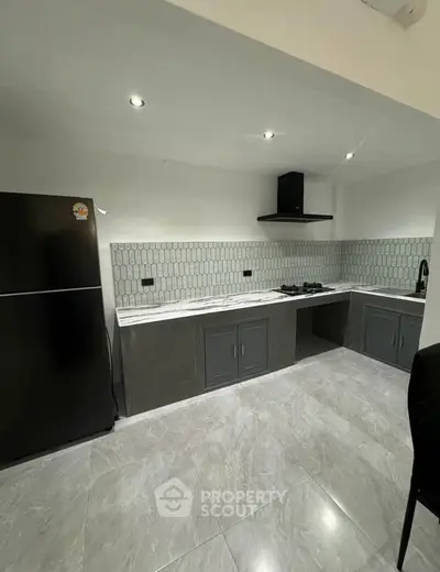 Modern kitchen with sleek design and gas stove, featuring elegant tile backsplash and spacious layout.