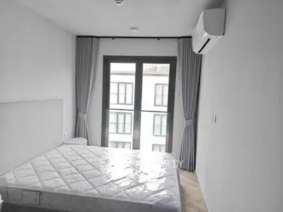 Modern bedroom with large window and air conditioning in a stylish apartment.