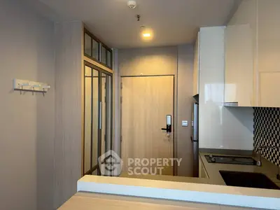 Modern kitchen with sleek cabinetry and electric stove in compact apartment