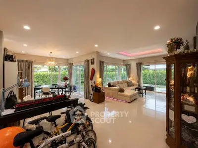 Spacious living room with elegant decor and garden view, perfect for family gatherings.
