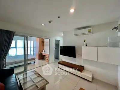 Modern open-plan living room with sleek furniture and bedroom view