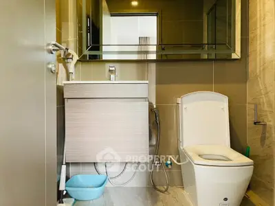 Modern bathroom with sleek fixtures and large mirror in a contemporary apartment.