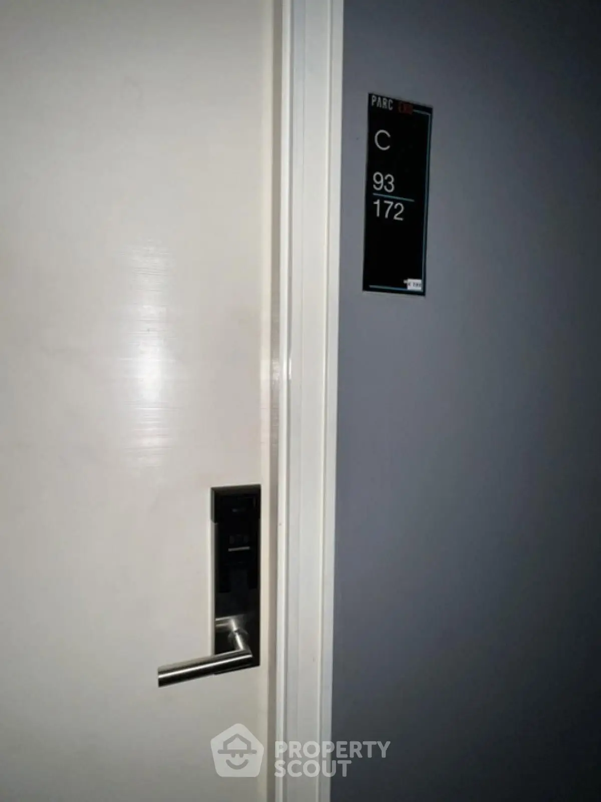 Modern apartment door with electronic lock and room number signage.