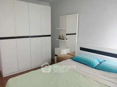 Modern bedroom with sleek white wardrobe and cozy bed setup