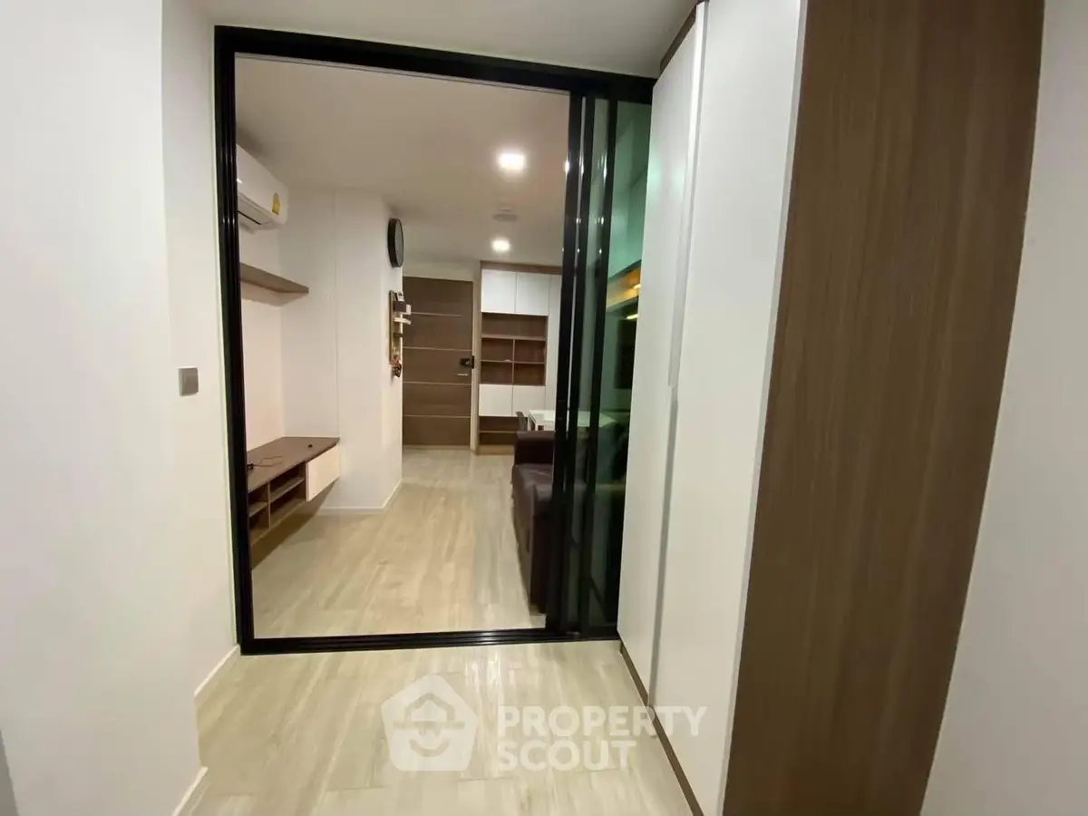 Modern apartment interior with sliding glass doors and wooden flooring