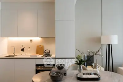 Modern kitchen with sleek cabinetry and elegant dining setup in a stylish apartment.