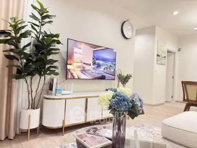 Stylish living room with modern decor and wall-mounted TV, perfect for relaxation.