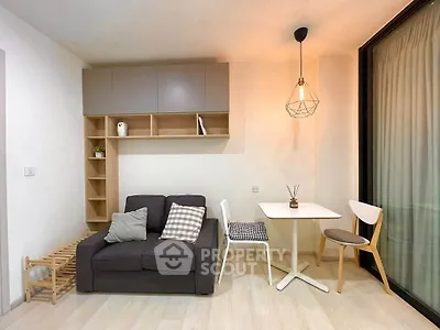 Modern living room with cozy sofa, stylish lighting, and dining area in a compact apartment.