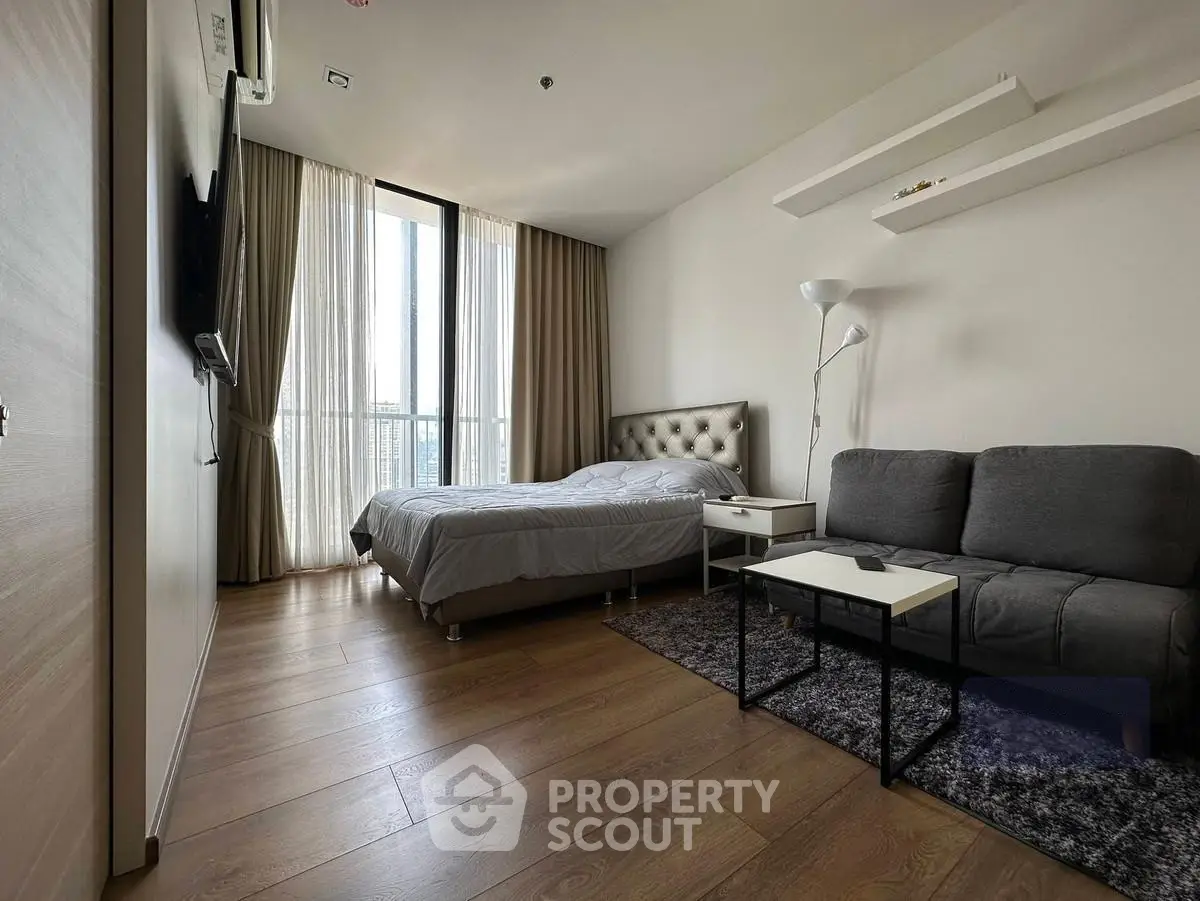 Modern bedroom with cozy seating area and natural light