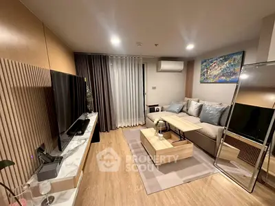 Modern living room with stylish decor, large TV, and cozy seating area in a contemporary apartment.