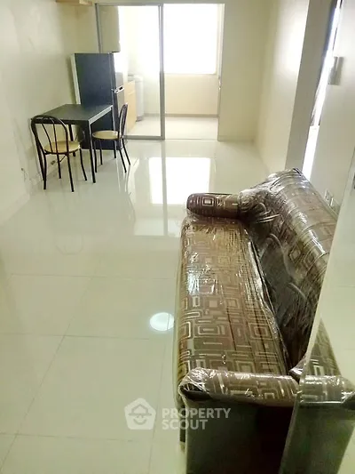 Spacious living room with glossy tiled floors and modern furniture in a bright apartment.