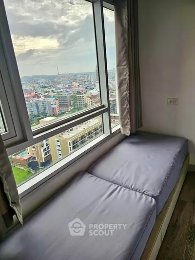 Stunning city view from cozy window seat in modern high-rise apartment