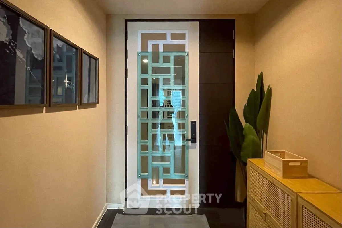 Stylish modern apartment entrance with decorative door and elegant hallway decor.