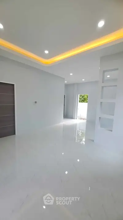Spacious modern living room with sleek white flooring and recessed lighting