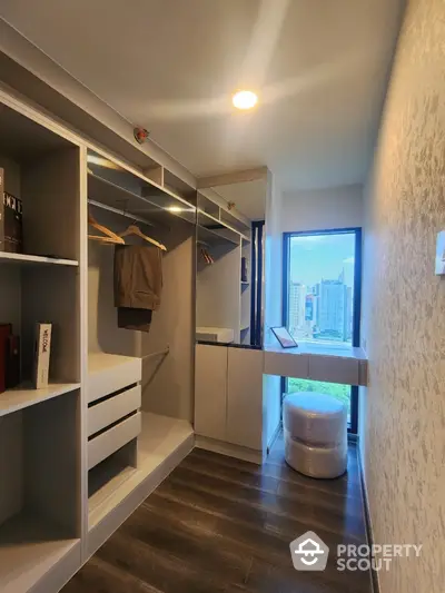 Modern walk-in closet with city view, featuring sleek storage solutions and elegant design.