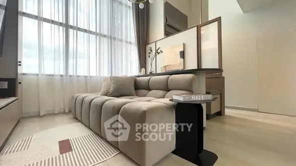 Modern living room with plush sofa and large window, elegant decor