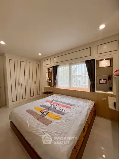 Spacious bedroom with built-in wardrobes and large window for natural light.