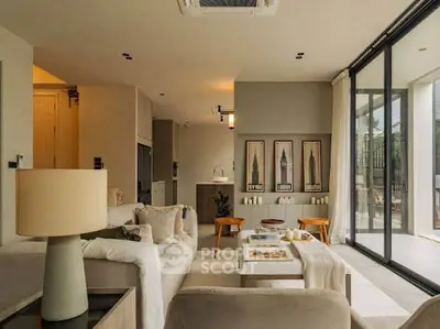 Luxurious living room with modern decor and large glass doors opening to a scenic view.