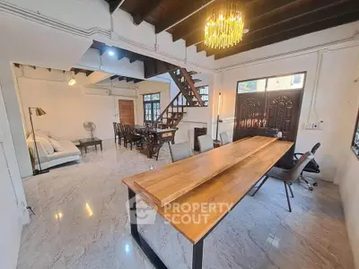 Spacious open-plan living and dining area with modern furnishings and stylish lighting.