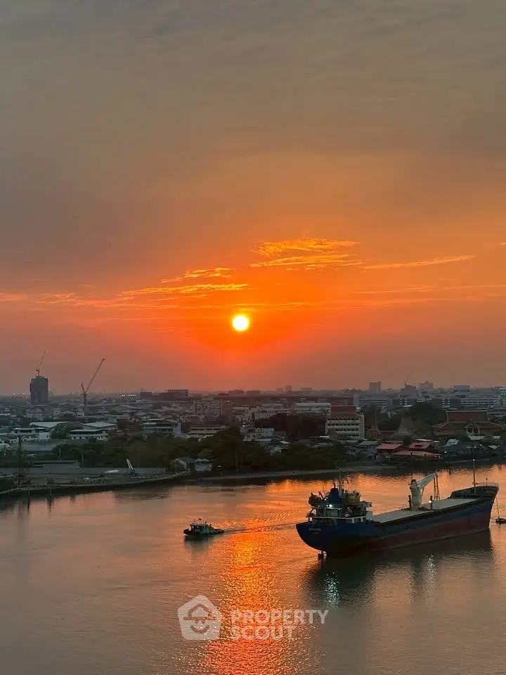 Stunning sunset view over a river with a ship, perfect for waterfront property listings.