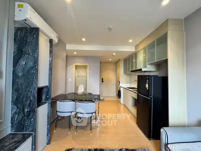 Modern open-plan living room and kitchen with sleek design and stylish furniture.
