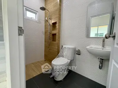 Modern bathroom with sleek shower and elegant fixtures in a contemporary home.