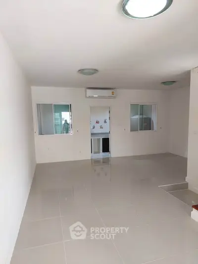 Spacious modern living room with glossy tile flooring and air conditioning.