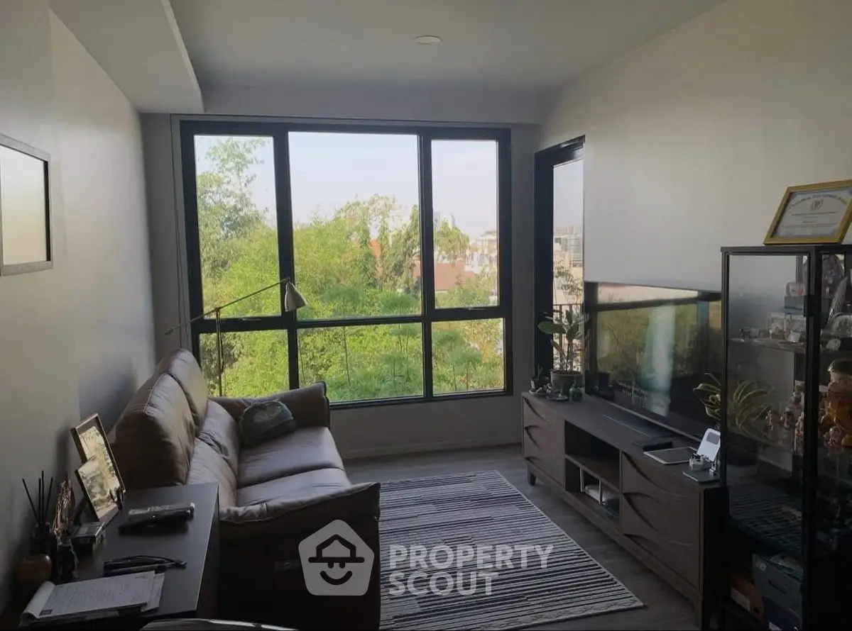 Cozy living room with large windows and scenic view, perfect for relaxation.