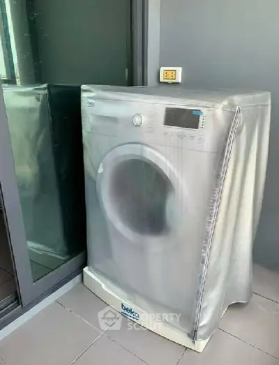 Modern washing machine on a balcony with protective cover, ideal for urban apartments.