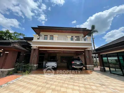 Stunning two-story house with spacious driveway and elegant architectural design under a clear blue sky.