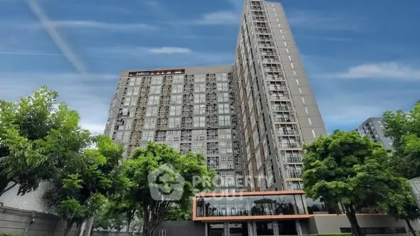 Modern high-rise building with lush greenery and clear blue sky