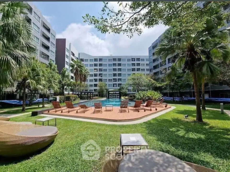 Luxurious apartment complex with lush garden and inviting pool area, perfect for relaxation and leisure.