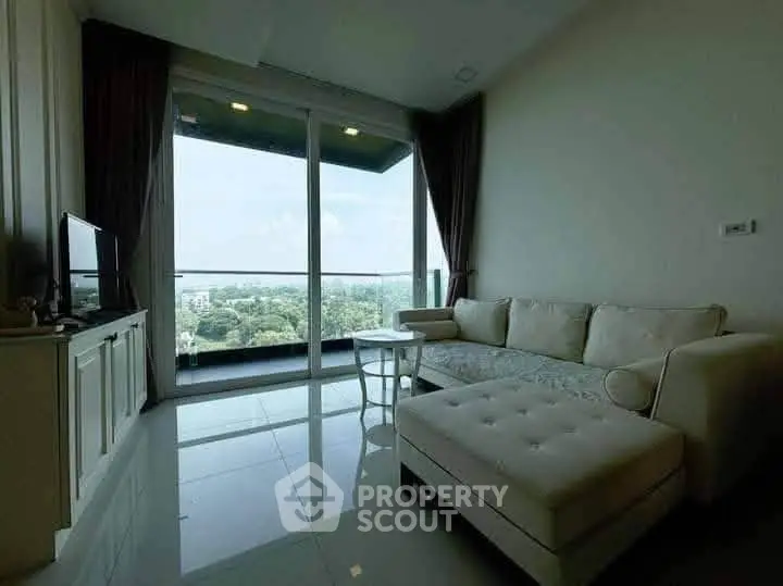 Spacious living room with large windows offering a stunning view of greenery.