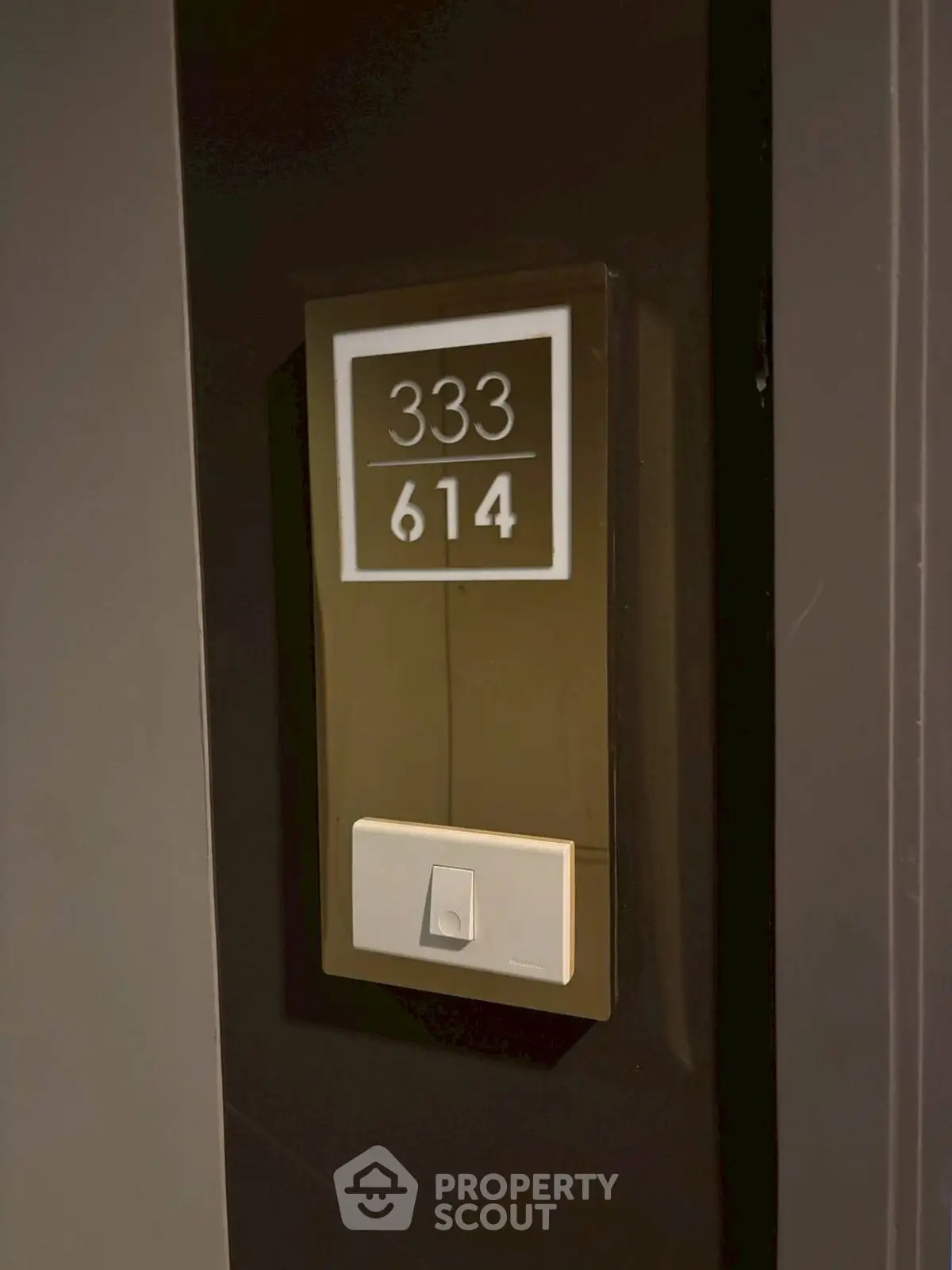 Modern apartment door with sleek number plaque and doorbell, showcasing contemporary design.