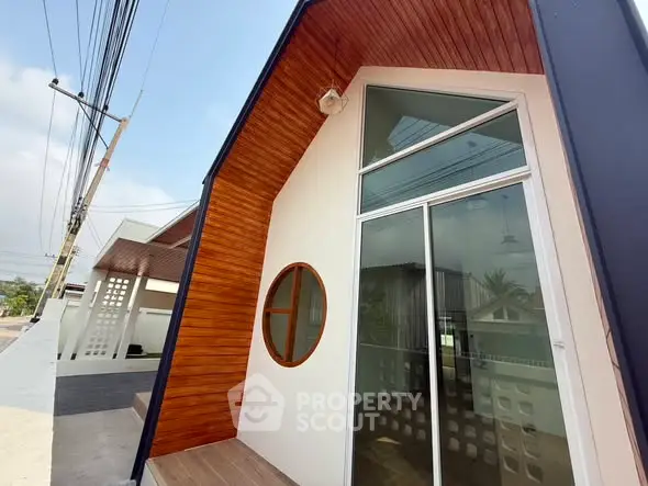 Modern architectural exterior with wooden accents and large windows in a contemporary home design.