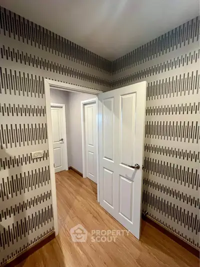 Stylish hallway with modern wallpaper and wooden flooring in a contemporary home.