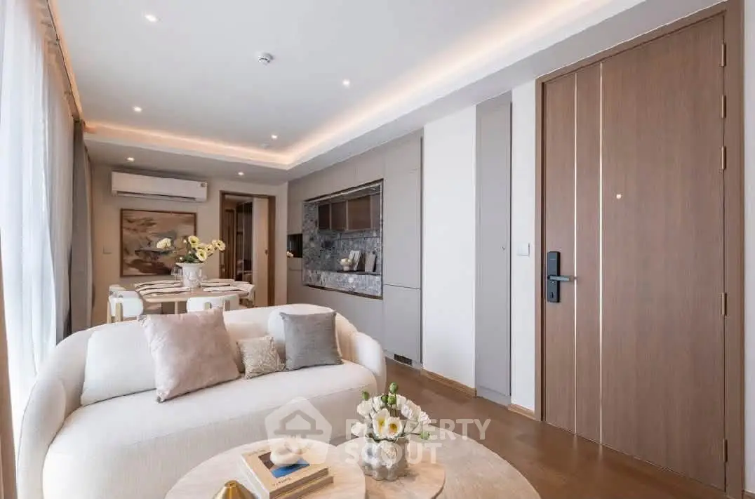 Elegant living room with modern decor and open dining area, featuring stylish furniture and ambient lighting.