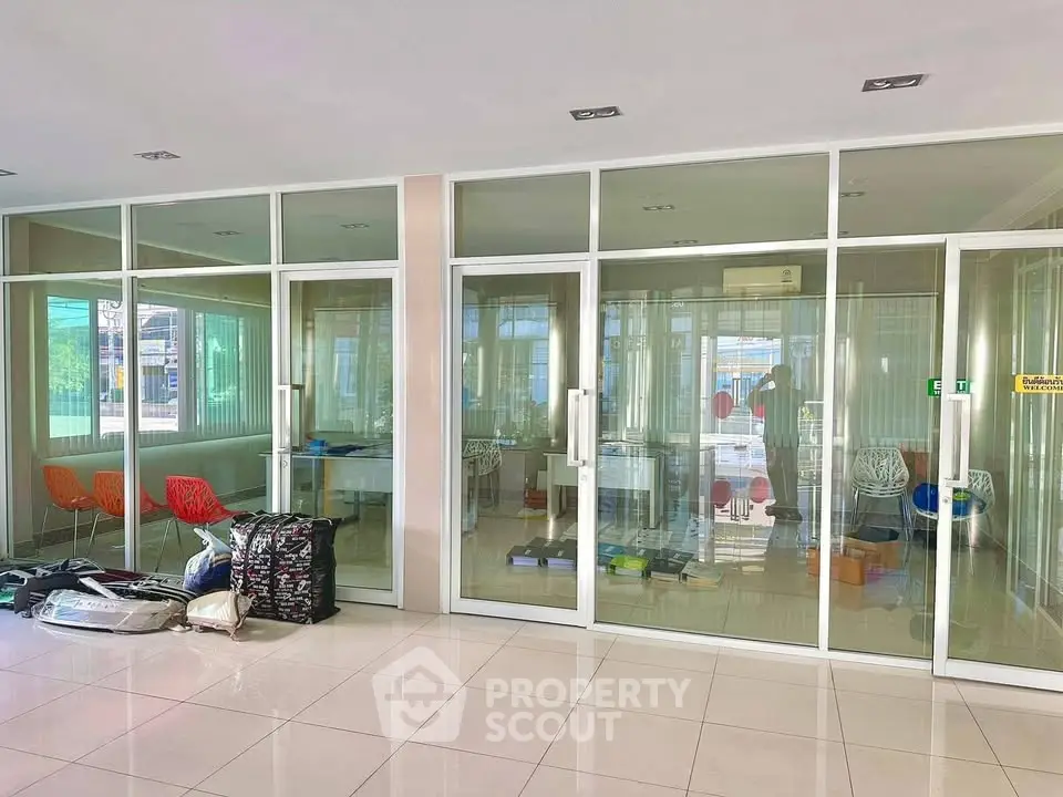 Spacious office space with glass partitions and modern furnishings, ideal for a professional work environment.