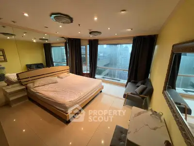 Luxurious bedroom with city view, featuring modern furnishings and large windows for natural light.