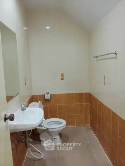Compact bathroom with modern fixtures and neutral tile design