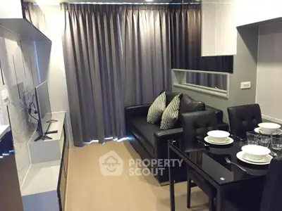 Modern living room with sleek black furniture and dining area in a stylish apartment.