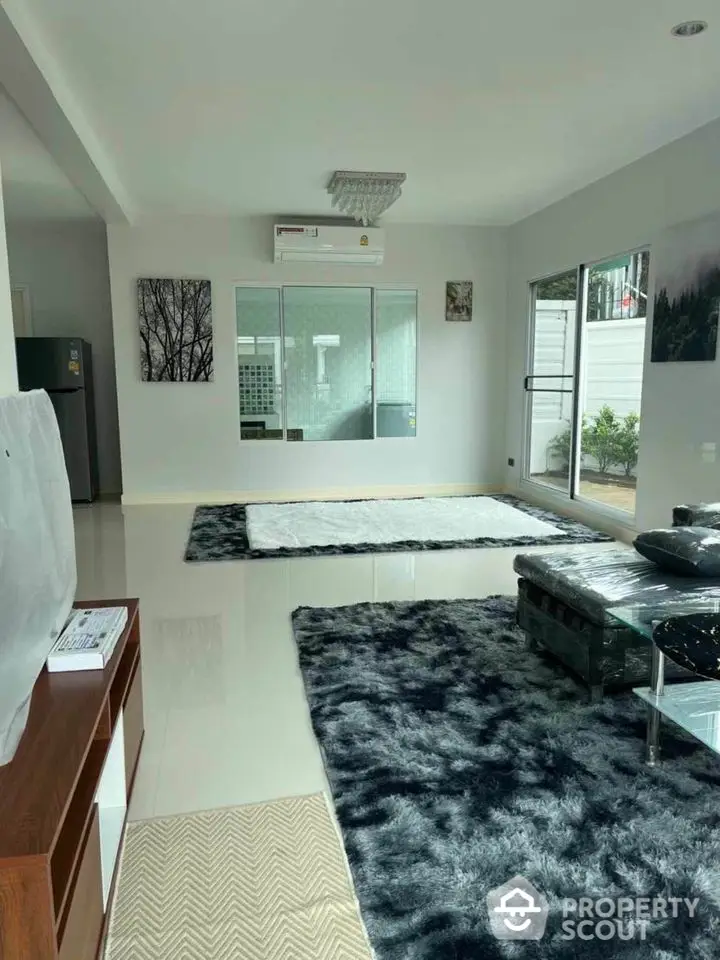 Spacious modern living room with plush rugs and natural light