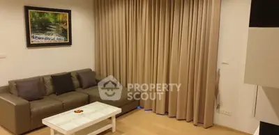 Cozy living room with modern sofa and elegant curtains, perfect for relaxation.