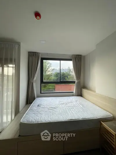 Cozy bedroom with large window and natural light, featuring a comfortable bed and modern design.