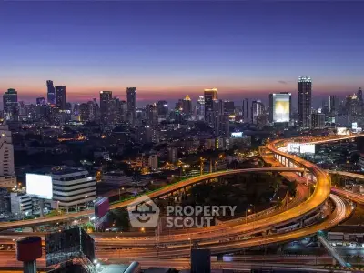 Stunning cityscape view with illuminated highways and skyline at dusk, perfect for urban real estate appeal.
