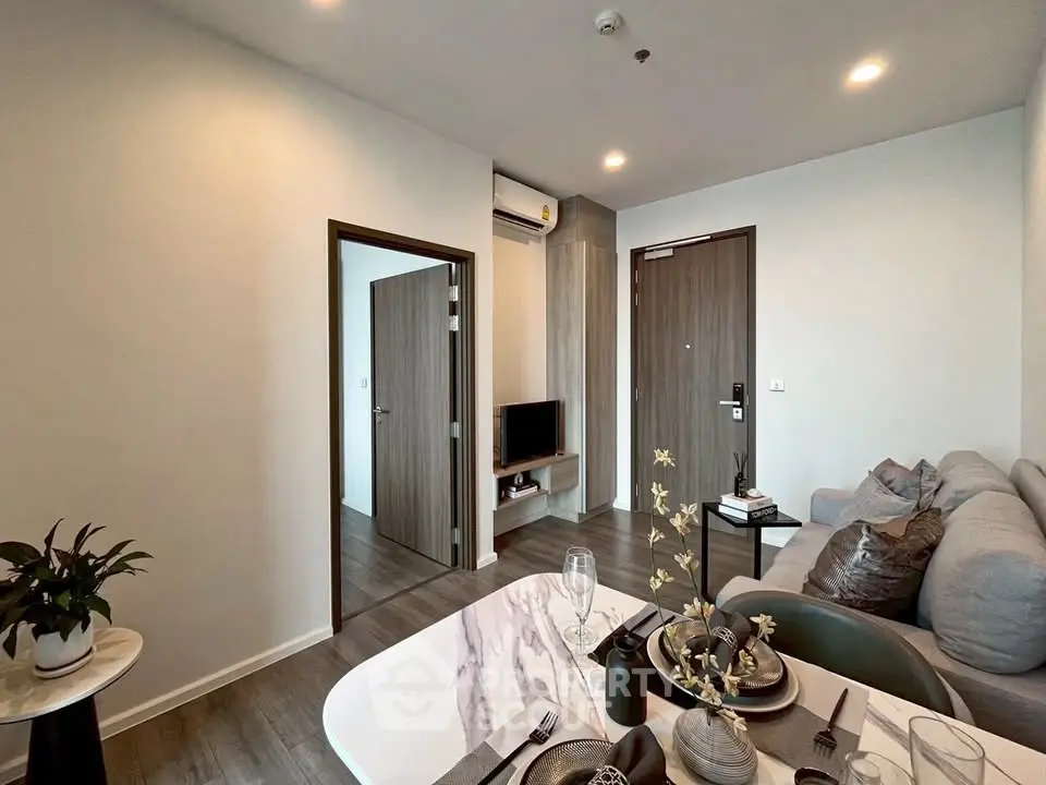 Modern living room with stylish decor and open layout, featuring a cozy sofa and elegant dining area.